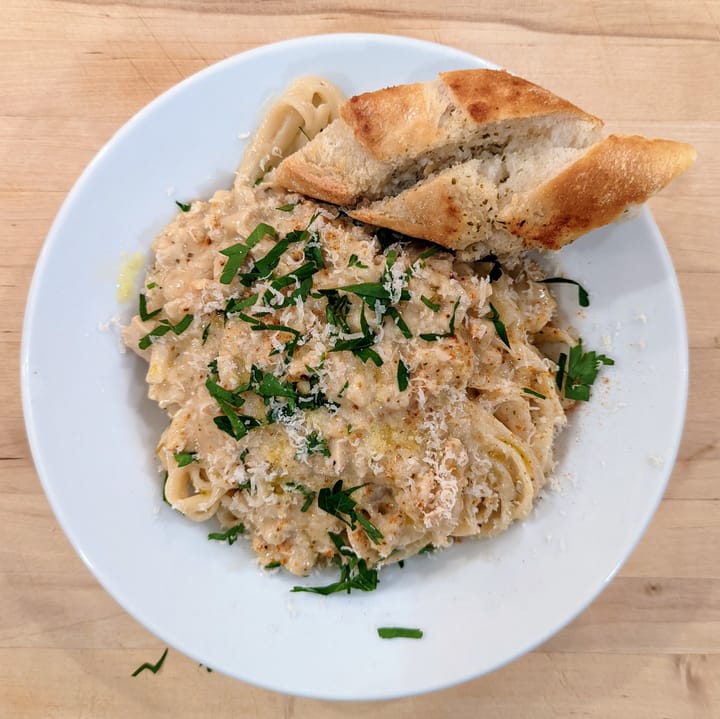 A bowl full of Creamy Clam Linguine that is nicely garnished with fresh basil.