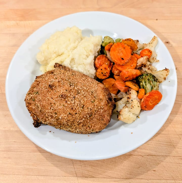 A Quake and Bake Pork Chop with a side of Frozen Mixed Vegetables and mashed potatoes.  An amazing and quick weeknight meal.
